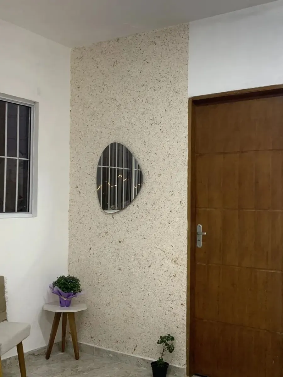 Hall de entrada com parede revestida em pedra natural tom claro